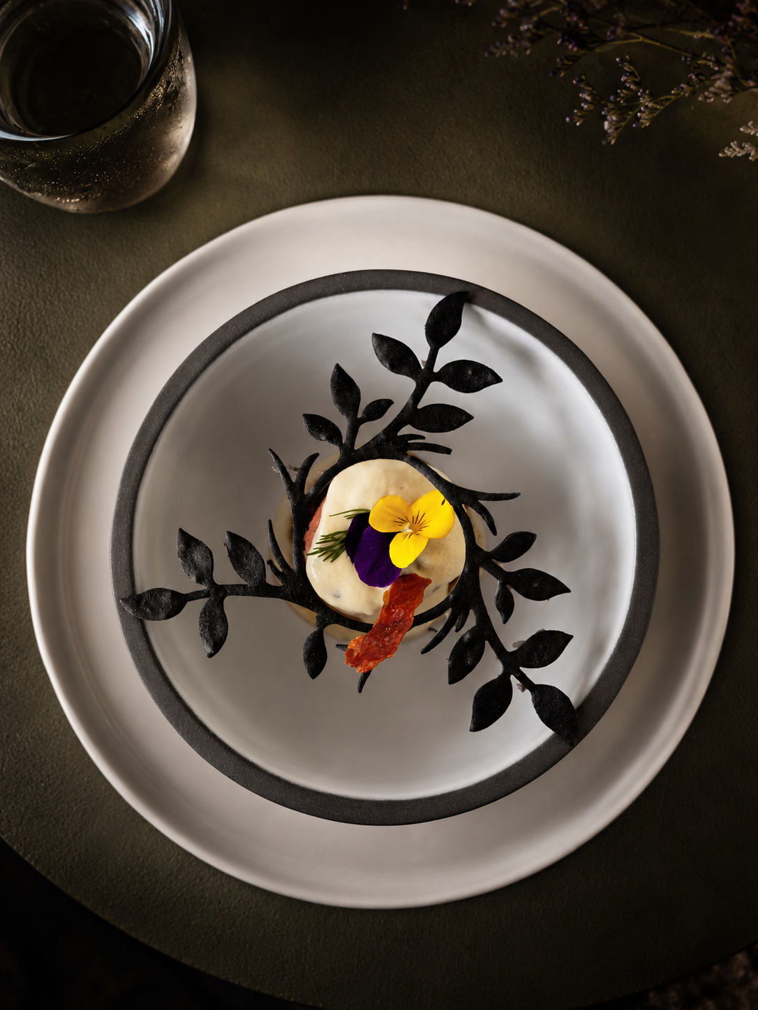 Plated course framed by a black floral tuile