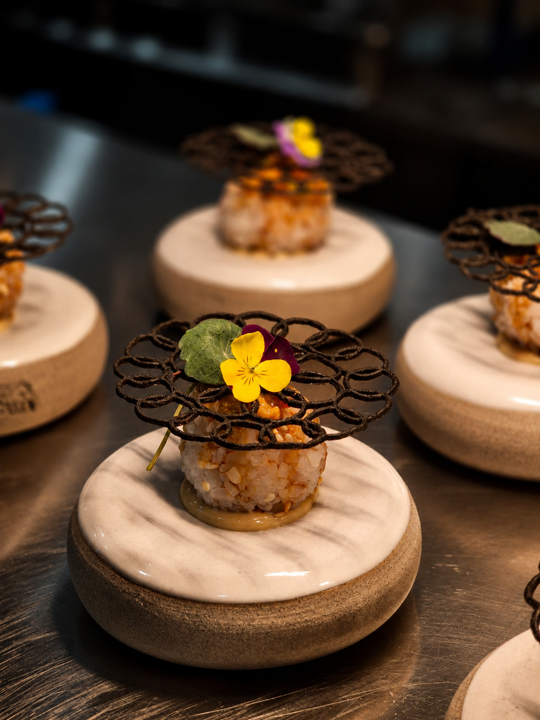 Petit four with edible flowers on a ceramic pedestal